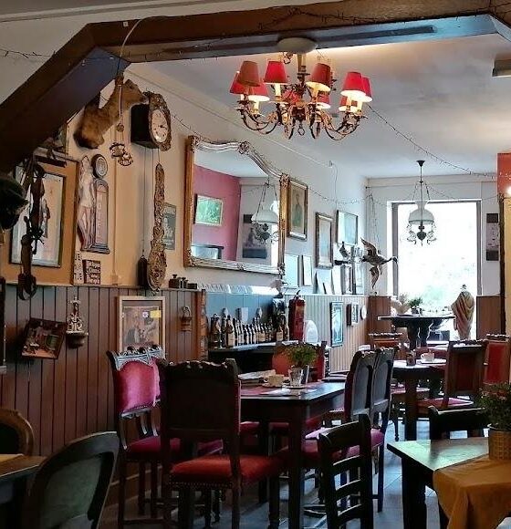 Het bruine café van binnen met houten balken, tafels en oude lampen