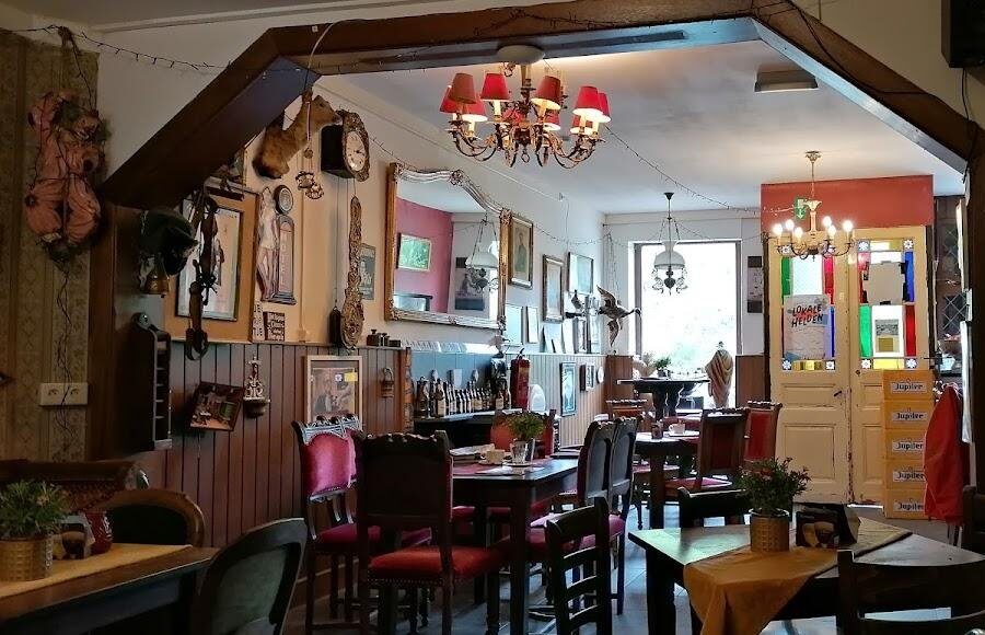 Het knusse bruine café met houten balken, tafels en rode stoelen